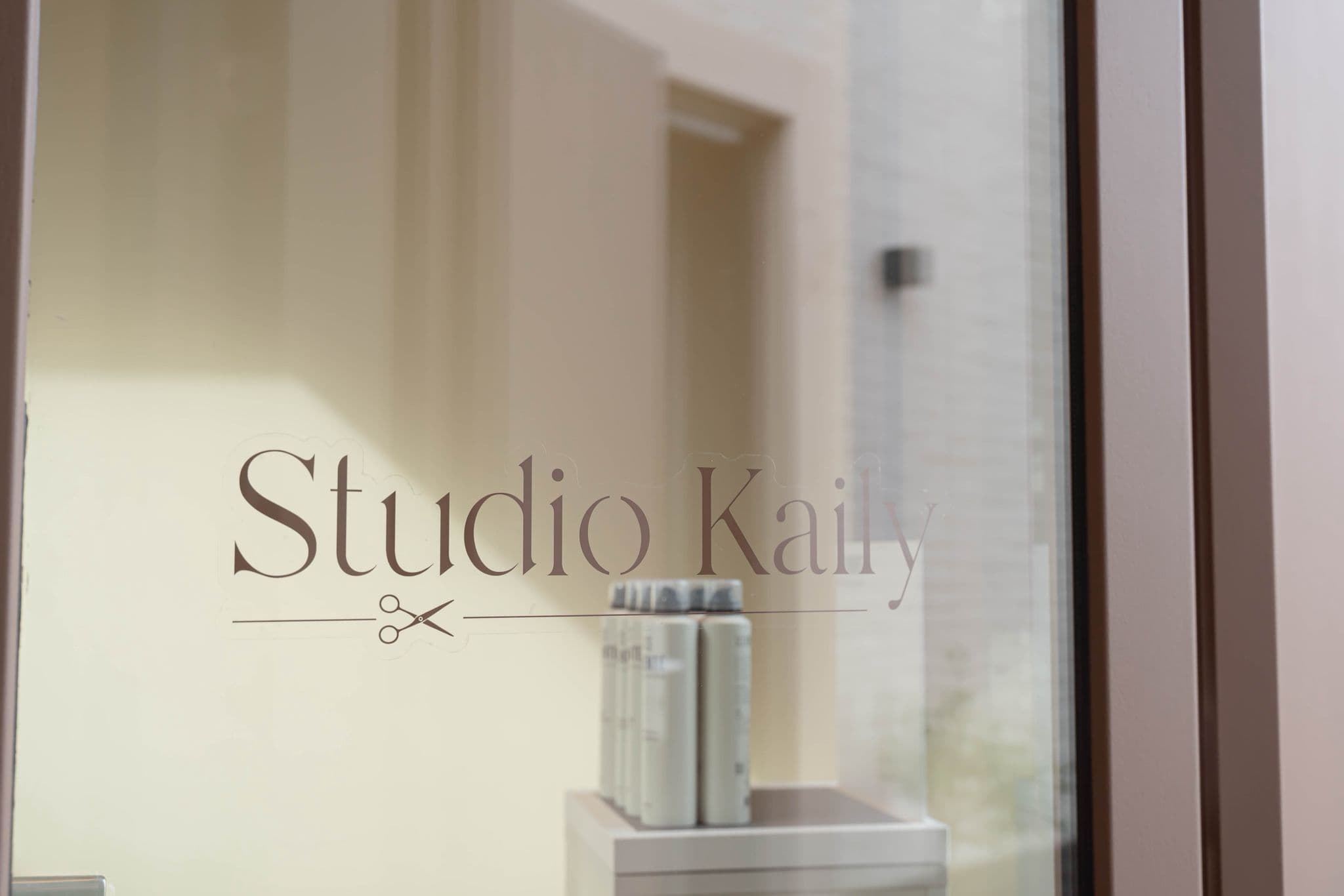 Logo van Studio Kaily op de glazen voordeur